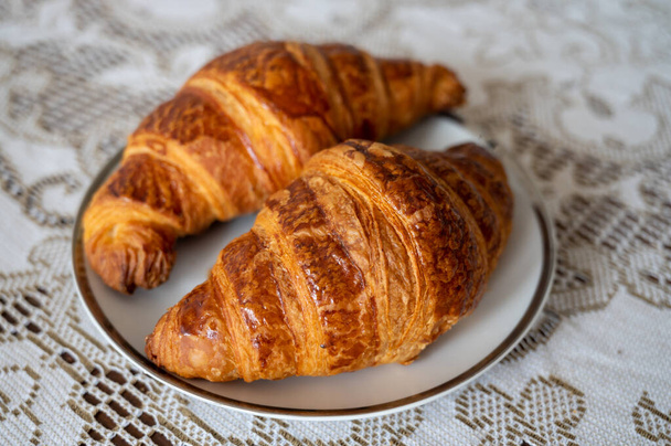 Δύο φρέσκα ψητά κρουασάν, παραδοσιακό γαλλικό πρωινό κοντά - Φωτογραφία, εικόνα