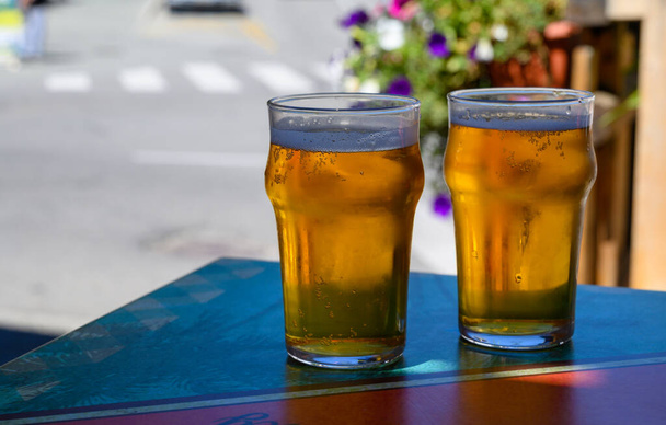 French cold beer in misted glasses served on outdoor terrace in small Alpine village in France close up - Photo, Image