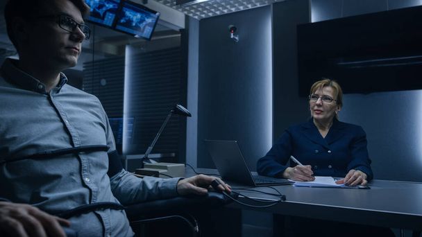 Female Special Agent Conducts Lie Detector Polygraph Test on a Young Suspect. Expert Examiner Questions Accused in Interrogation Room. Computer Measures Physiological indices. - Foto, afbeelding