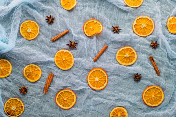 tranches d'orange séchées, bâtonnets de cannelle, anis étoilé sur mousseline bleue, vue de dessus, fond de cuisine du Nouvel An festif, - Photo, image