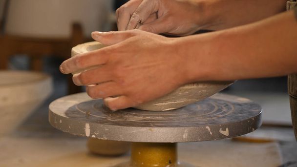 гончар працює з глиною, обробкою глини
 - Фото, зображення