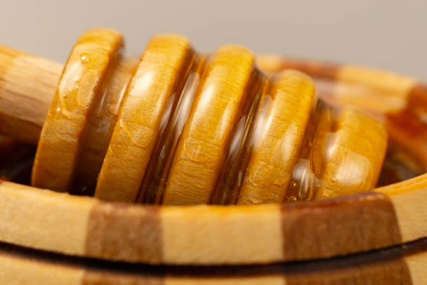 木製のディッパーから砂糖のペーストや美容ワックスが流れます。蜂蜜はスプーンから落ちる。マクロ写真 - 写真・画像
