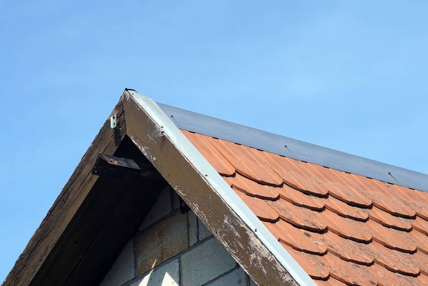 El techo de una antigua casa con grunge azulejos contra el cielo azul - Foto, imagen