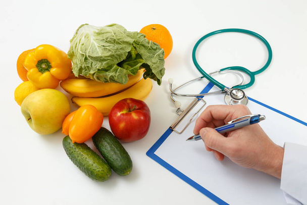 Nutritionist doctor writing diet plan on table. Right nutrition and slimming concept - Fotó, kép