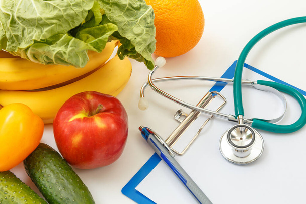 Nutrition and healthy eating. Fruits, vegetables, juice and stethoscope - 写真・画像