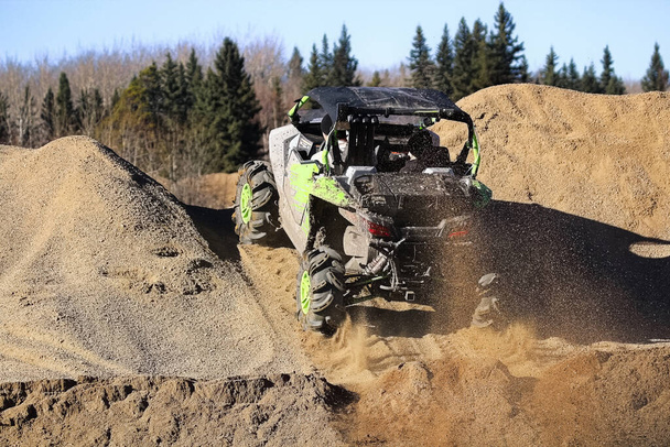 A side-by-side ripping up dirt as it goes up a gravel hill. - Photo, Image