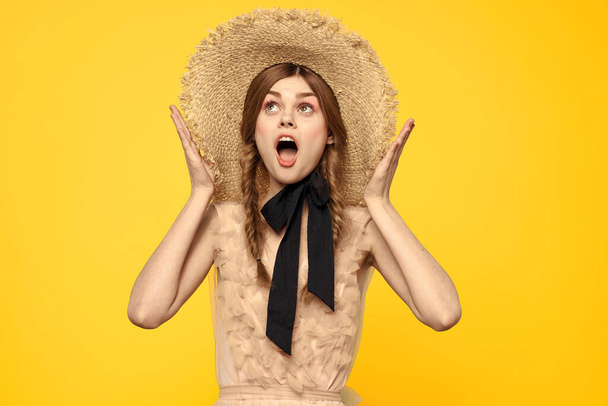 Portrait woman in straw hat on yellow background cropped view of summer dress model pigtails romance - Fotó, kép