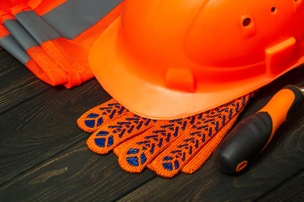 Master rakentajan oranssi suojavarusteet pinottu mustat laudat ennen työtä - Valokuva, kuva