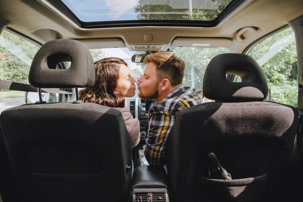 Άντρας με γυναίκα να φιλιέται στο αυτοκίνητο. οδικό ταξίδι - Φωτογραφία, εικόνα