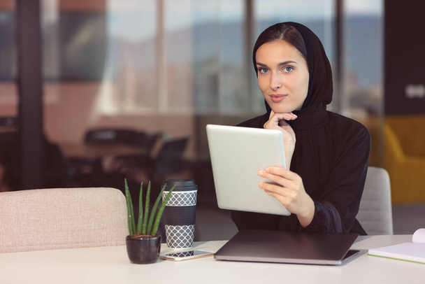 professional young muslim business woman using mobile digital tablet computer at work - Fotó, kép