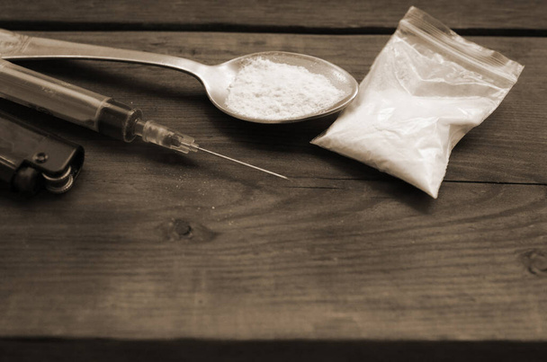 Uyuşturucu satıcılığı. Şırınga, çakmak ve tahta arka planda beyaz toz dolu kaşık. Eroin ve metamfetamin kullanılıyor. Uyuşturucu bağımlılığı kavramı - Fotoğraf, Görsel