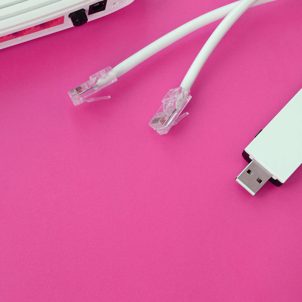 Internet router, přenosný USB wi-fi adaptér a internetové kabelové zástrčky leží na jasně růžovém pozadí. Položky vyžadované pro připojení k Internetu - Fotografie, Obrázek