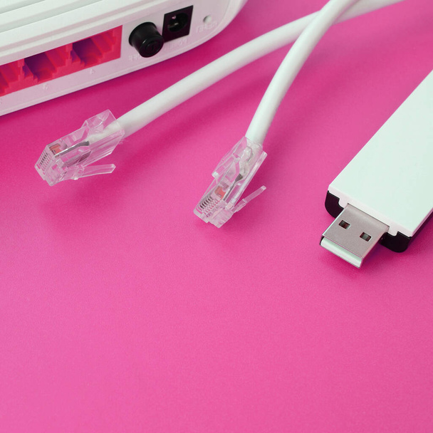 Інтернет-маршрутизатор, портативний USB wi-fi адаптер і інтернет-кабельні плуги лежать на яскраво-рожевому фоні. Елементи, необхідні для підключення до Інтернету - Фото, зображення
