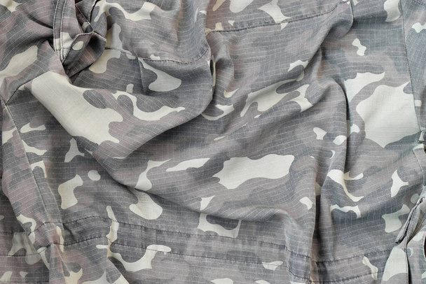 Camouflage background texture as backdrop for hunting or fishing design projects. Back side of hunters camouflage jacket with many pleats on crumpled fabric - Photo, Image