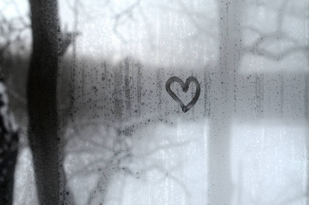 The heart is painted on the misted glass in the winter - Photo, Image