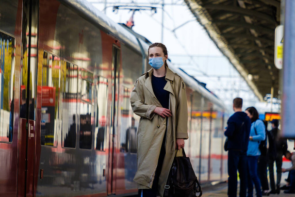 Moscow. Russia. October 4, 2020 A young woman wearing a protective medical mask stands on the platform of a metro station, waiting to board the train. The second wave of the coronavirus pandemic. - Foto, Bild