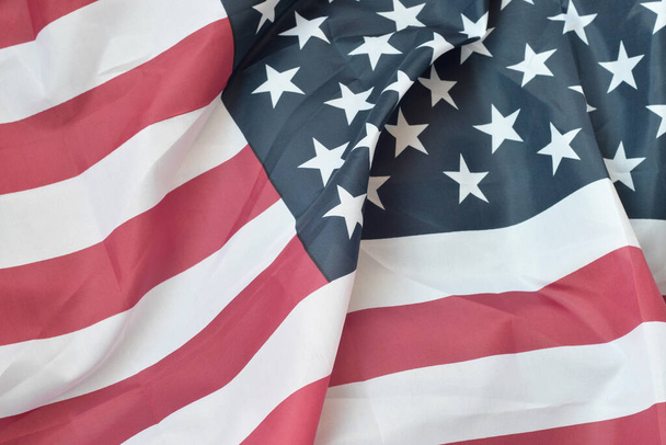 Primer plano de la bandera estadounidense sobre fondo liso. Colorido ondeando bandera horizontal de los Estados Unidos con estrellas y rayas
 - Foto, Imagen