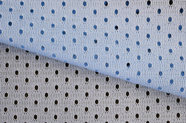 Niebieska siatka sport nosić tkaniny wzór tła. Niebieski kolor piłka nożna koszulka tkanina tkanina tekstury sportowe zużycie. Oddychający porowaty materiał poriferyczny wentylacja powietrzem z małymi otworami - Zdjęcie, obraz