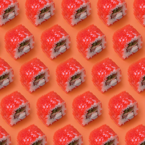 California Maki sushi rolls with caviar and masago on orange background close up. Minimalism top view flat lay pattern with Japanese food - Photo, Image