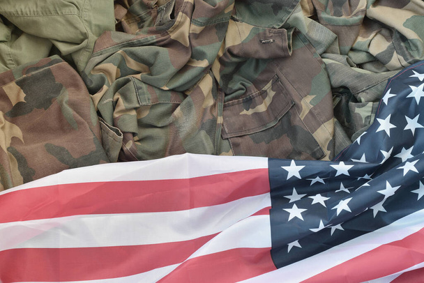Vlajka Spojených států amerických a složená vojenská uniforma. Vojenské symboly konceptuální pozadí banner pro americkou vlasteneckou dovolenou design s kopírovacím prostorem pro text - Fotografie, Obrázek