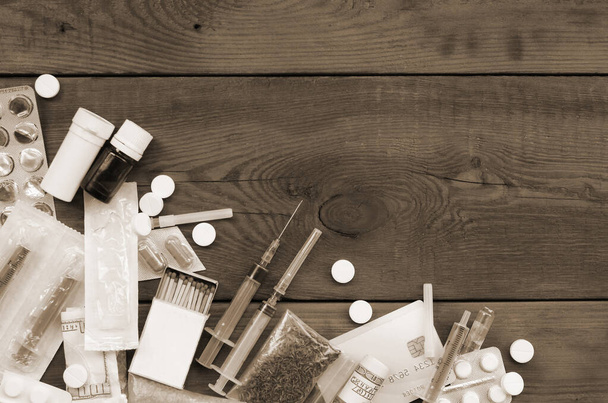 Auf einem alten Holztisch liegen viele Betäubungsmittel und Geräte zur Herstellung von Drogen. Drogendealer-Zeug. Kokain und Cannabis in vollem Zustand. Drogendeal-Konzept - Foto, Bild