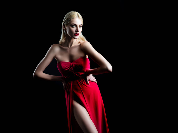 Girl fashion model with vogue red dress on black. - Foto, afbeelding