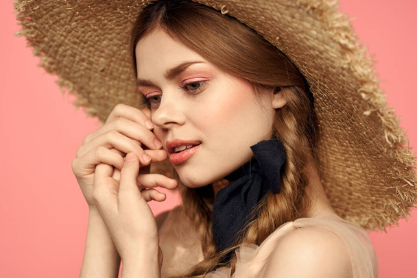 Portrait of a girl in a straw hat on a pink background emotions close-up beautiful face model pigtails - Photo, Image