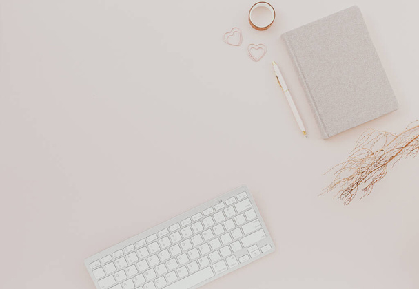 Stylish minimalistic workplace with keyboard, notebook on pastel pink background. flat lay, top view - Foto, Bild