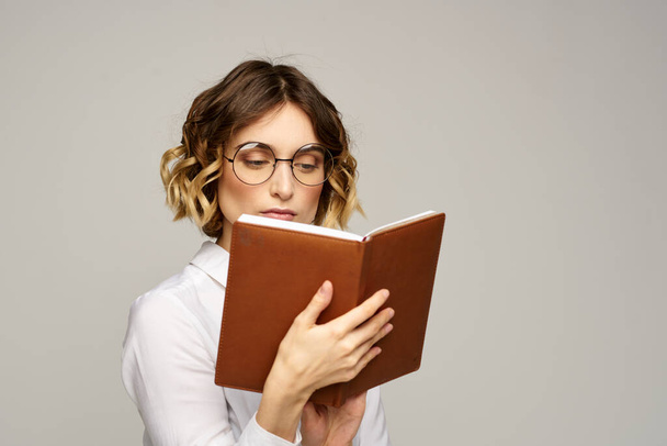 femme avec bloc-notes dans les mains travail d'affaires beige fond lunettes coiffure - Photo, image