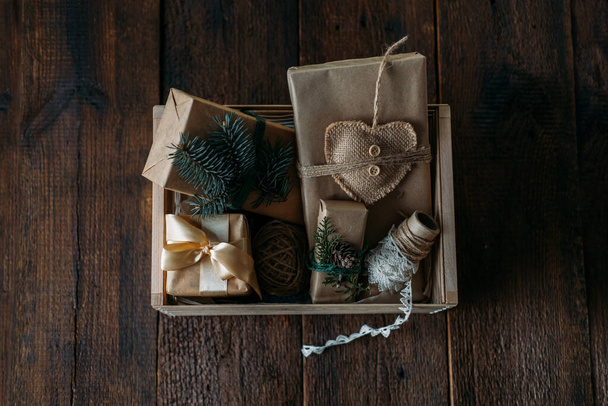 Sustainable Christmas, zero waste gifts, natural xmas decorations. Wrapping Christmas gifts in recycled brown paper in wooden care box. Vintage style Christmas packaging ideas - Zdjęcie, obraz