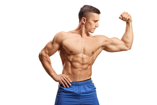 Strong muscular guy flexing one bicep muscle isolated on white background - Foto, immagini