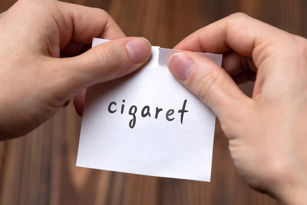 Kezek letépve papír felirattal cigaretta - Fotó, kép