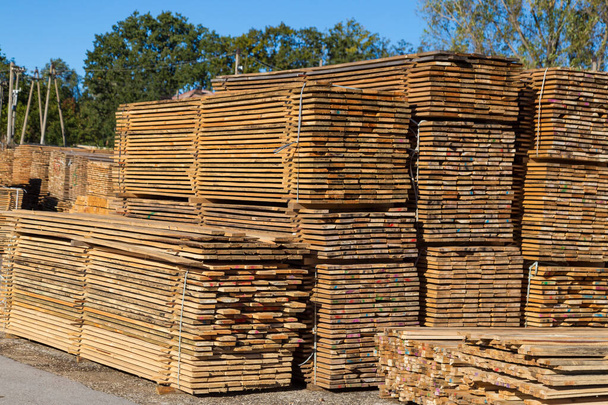 Ξύλινες σανίδες προς πώληση. Στοίβες επεξεργασμένου ξύλου στην ξυλαποθήκη. Ιστορικό - Φωτογραφία, εικόνα