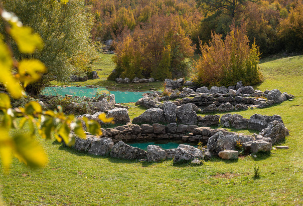 Antiguos pozos romanos Rajcica situado en el campo de Croacia, a 40 km de Split. Formaciones de piedra redonda escondidas en el bosque cubierto de hermosa hierba verde. Pastos para vacas locales - Foto, imagen