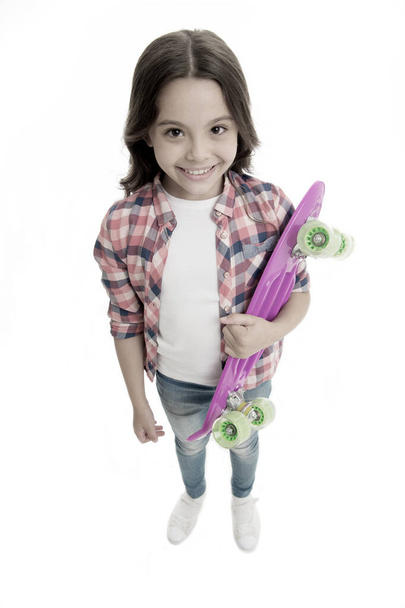 Fond of skateboarding. Kid girl happy carries penny board. Child likes skateboarding with penny board. Modern teen hobby. How to ride skateboard. Girl happy face carries penny board white background - Foto, Bild