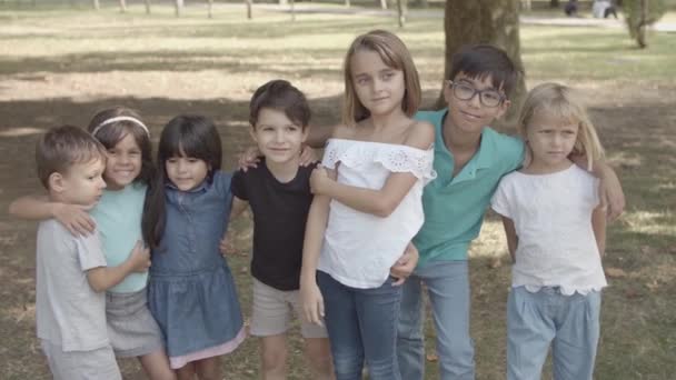 Többnemzetiségű gyerekek állnak együtt, ölelkeznek és mosolyognak - Felvétel, videó
