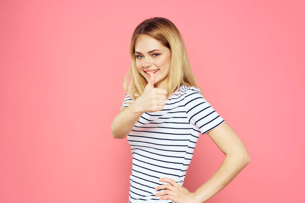 Vrolijke vrouw gestreepte t-shirt lifestyle emoties en gebaren met handen roze achtergrond - Foto, afbeelding