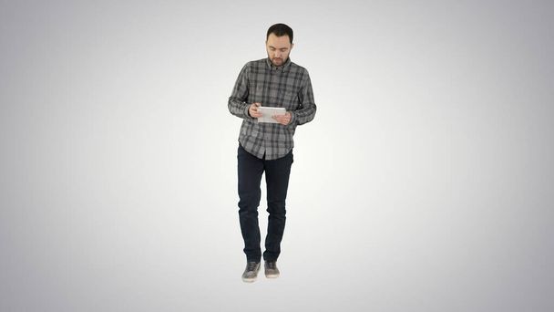 One guy holding and using one gradient tablet on gradient backgr - Photo, Image
