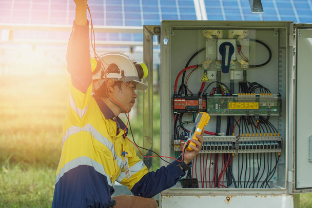 I lavoratori utilizzano il multimetro per misurare la tensione dei fili elettrici prodotti dall'energia solare per confermare i sistemi che funzionano normalmente. - Foto, immagini