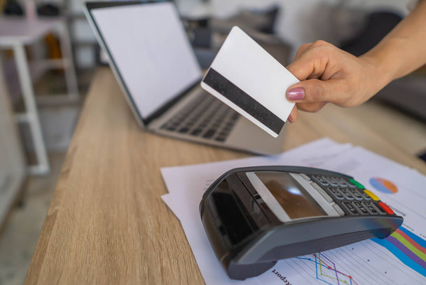 Bizneswoman za pomocą karty kredytowej dokonała płatności za pomocą urządzenia EDC. - Zdjęcie, obraz