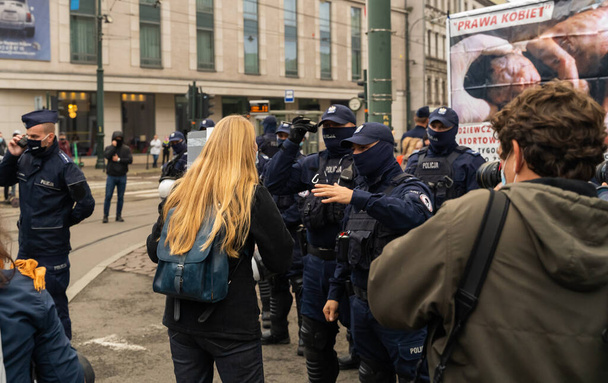 Cracovia, Polonia - 25 ottobre 2020: i polacchi si sono riuniti indossando una maschera durante la pandemia per protestare contro una proposta legislativa per un divieto totale di aborto nel centro principale della città - Foto, immagini