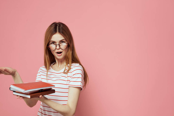 Młoda studentka z książkami o różowych okularach tła na twarzy instytucji edukacyjnej widok przycięty - Zdjęcie, obraz