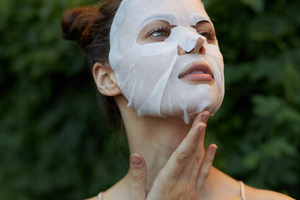Bella donna maschera bianca Inclinato la testa indietro e alla moda foglie di dermatologia acconciatura sullo sfondo - Foto, immagini