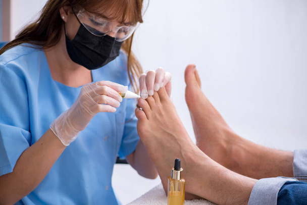 Podólogo tratando los pies durante el procedimiento - Foto, Imagen