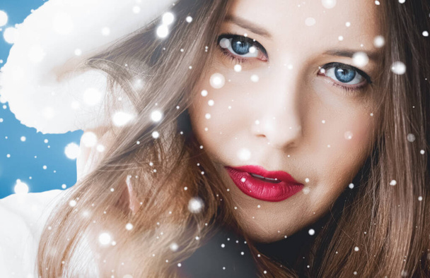 Boldog Karácsonyt és téli nyaralást portré fiatal nő fehér kapucnis szőrme kabát, hó kék háttér, divat és életmód - Fotó, kép