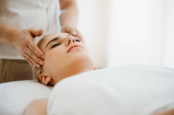 Mulher bonita recebendo cabeça e massagem facial no salão de spa. Conceito de cuidados de saúde corporal e massagem tradicional tailandesa relaxar - Foto, Imagem