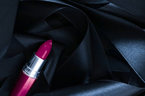 Rouge à lèvres violet sur fond de soie noire, maquillage de luxe et cosmétiques de beauté - Photo, image