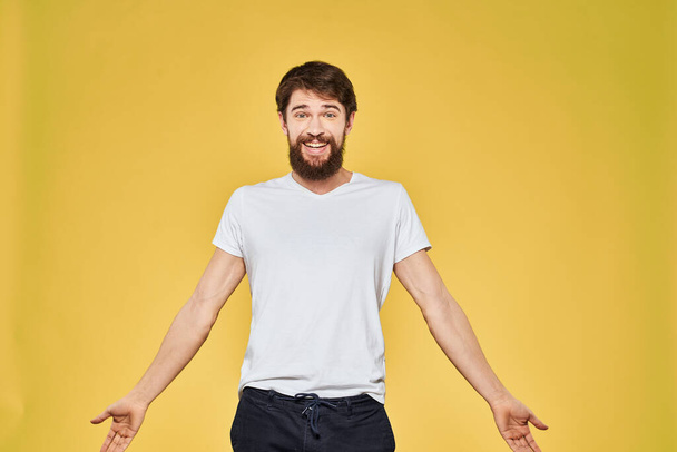 Man gesturing with hands emotions lifestyle white t-shirt yellow isolated background - Фото, зображення