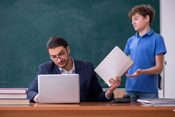Young male teacher and schoolboy in the classroom - Fotoğraf, Görsel