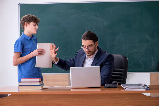 Young male teacher and schoolboy in the classroom - Foto, immagini